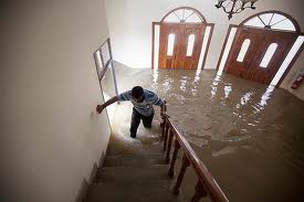 man walking up stairs in flooded house