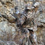 man in camo hunting with bow
