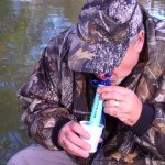 man drinking from a lifestraw personal purification filter