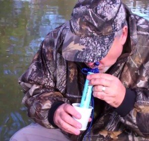 man drinking from a lifestraw personal purification filter